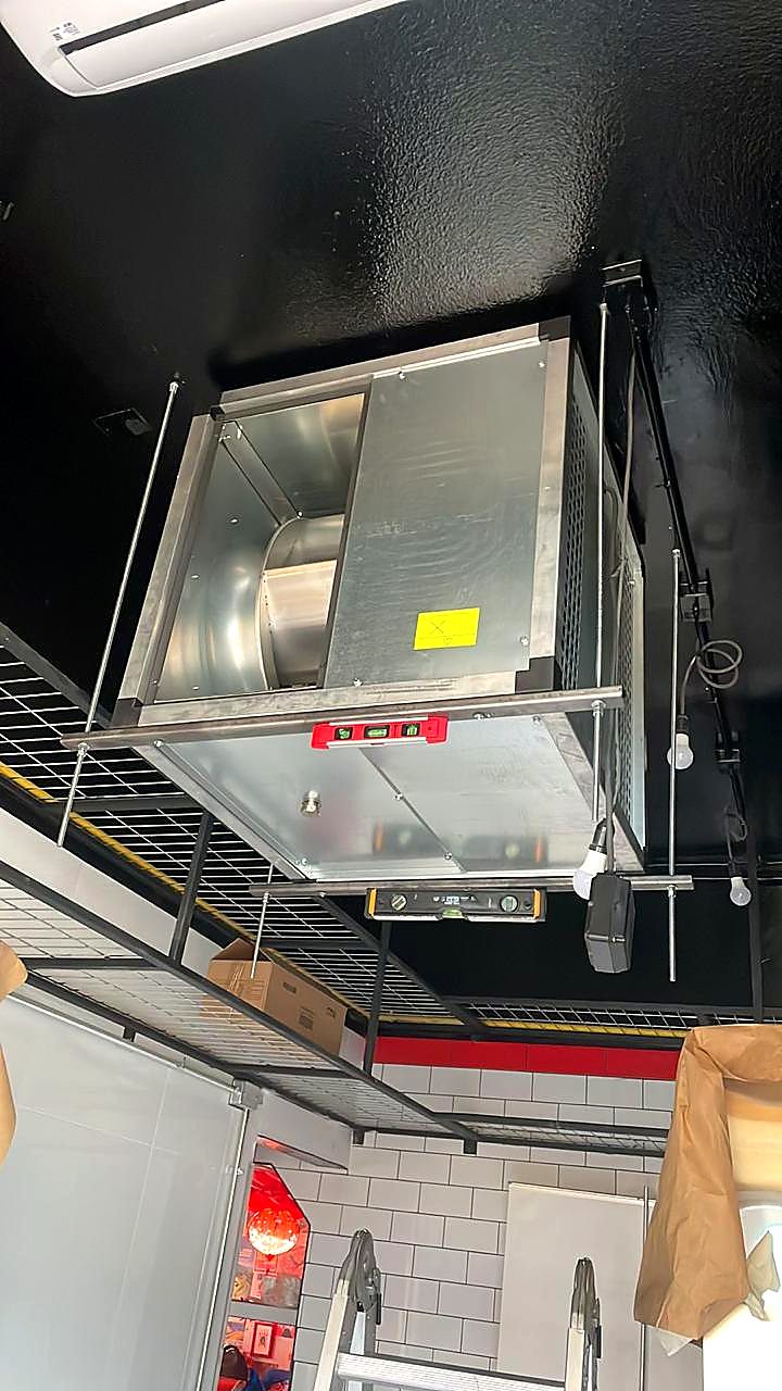 Equipo de aire acondicionado y caja de ventilación instalados en un local