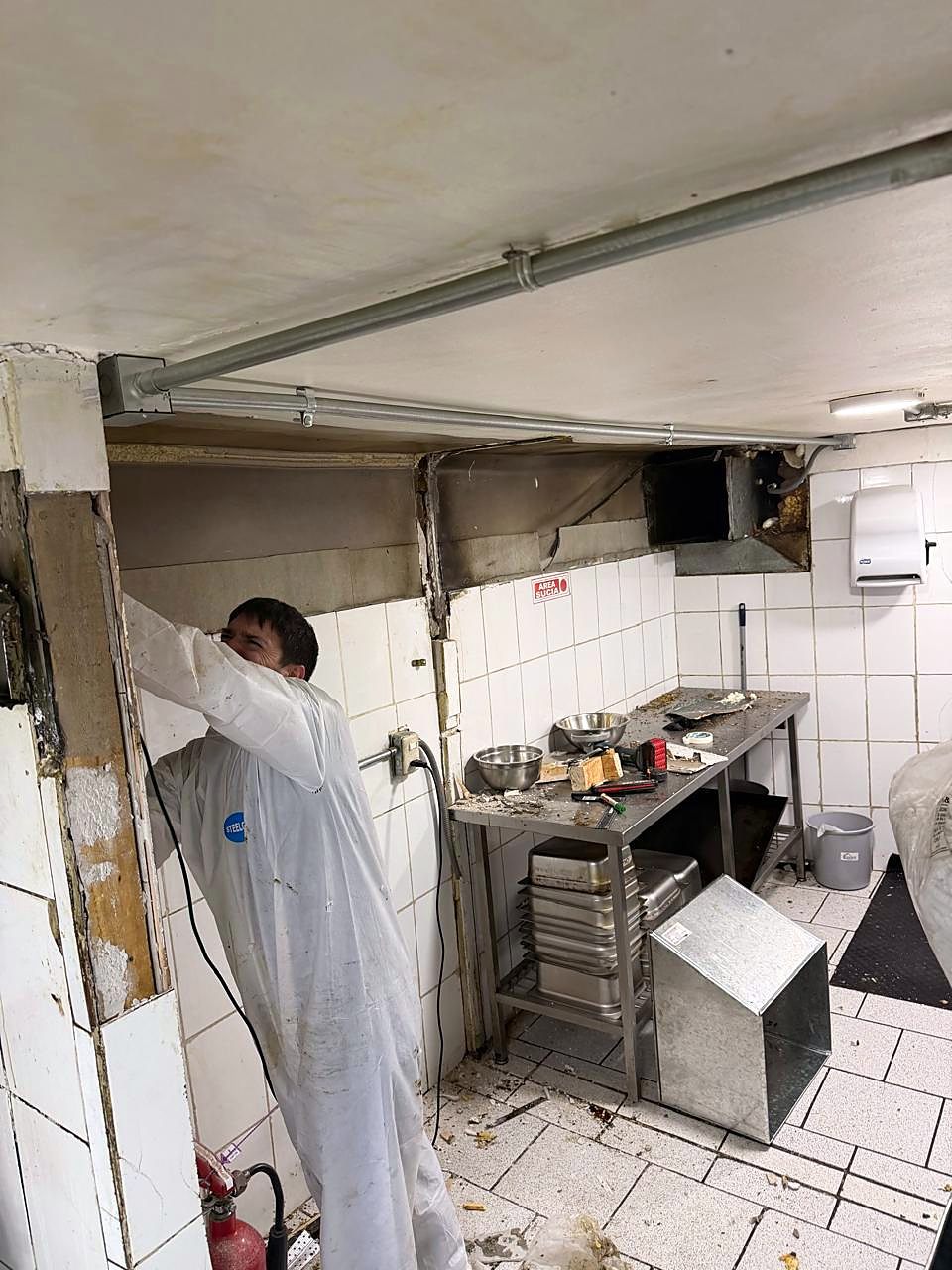 Técnico realizando mantención de ductos en una cocina