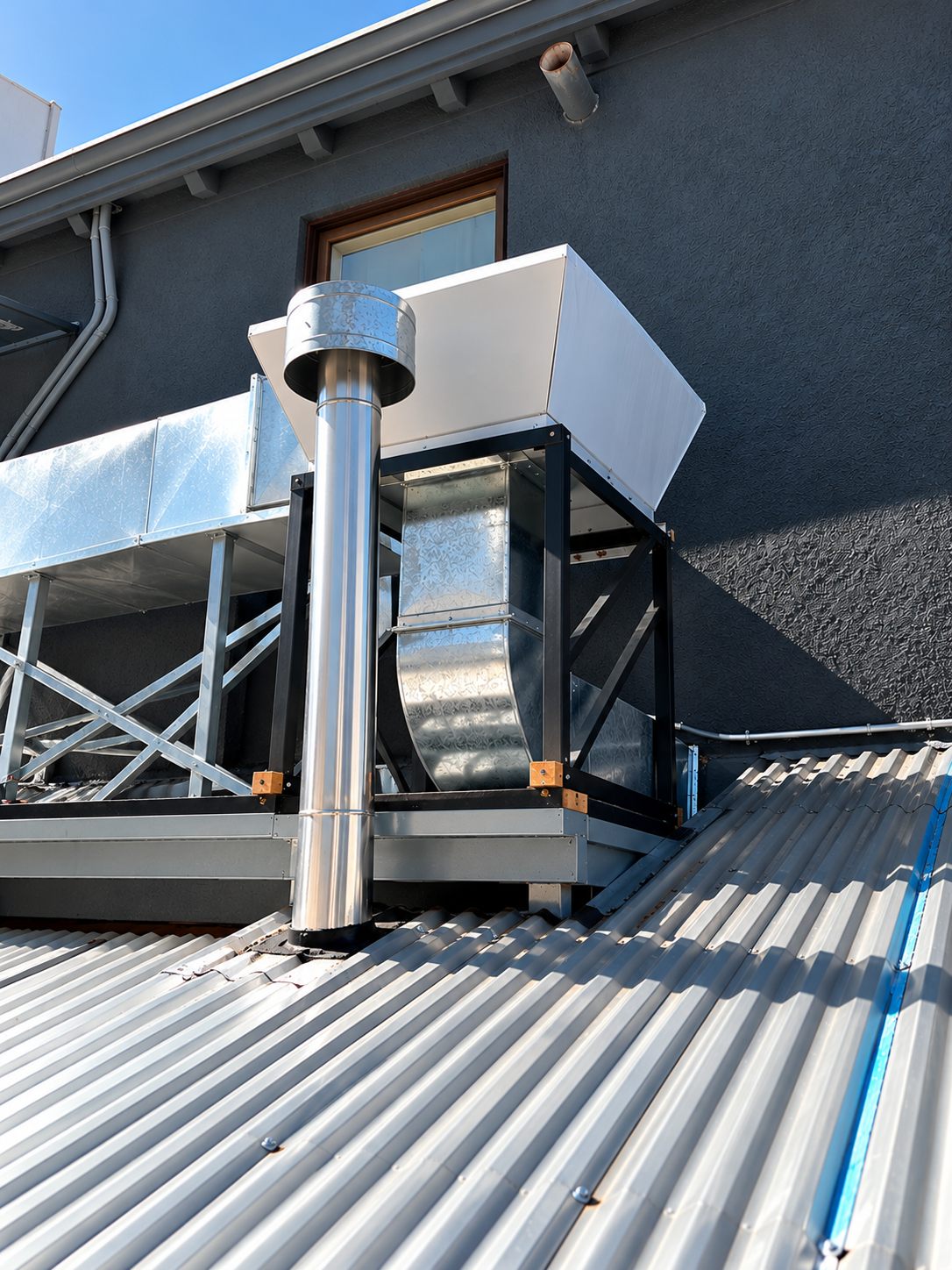 Ducto galvanizado y chimenea de acero inoxidable instalados sobre techumbre